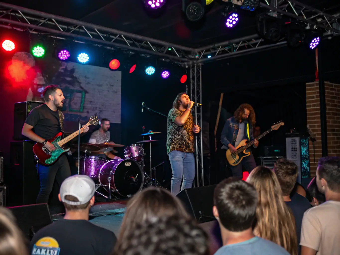 A dynamic image of a live music performance organized by ARBRAZIK, featuring a band on stage with colorful lighting and an enthusiastic audience, capturing the excitement and energy of the event.